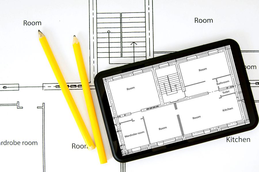 紙の間取り図とタブレットに映された間取り図