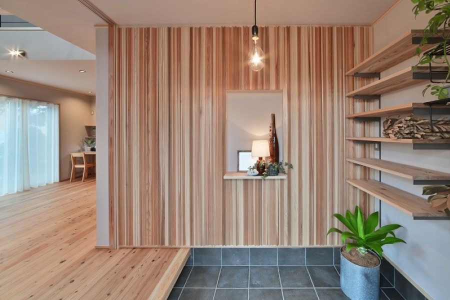 土間に観葉植物が置かれた、棚とニッチのある玄関