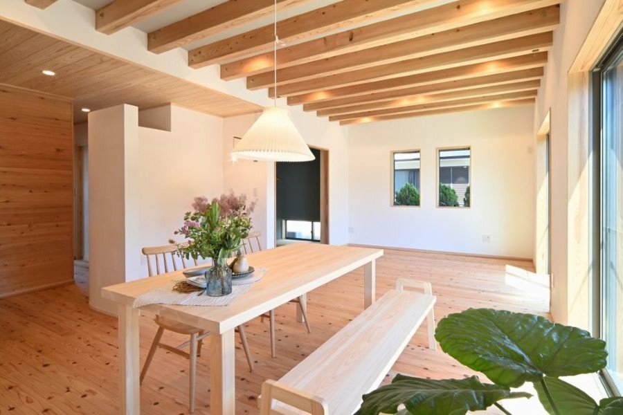 花が飾られているダイニングテーブルが置かれた住宅