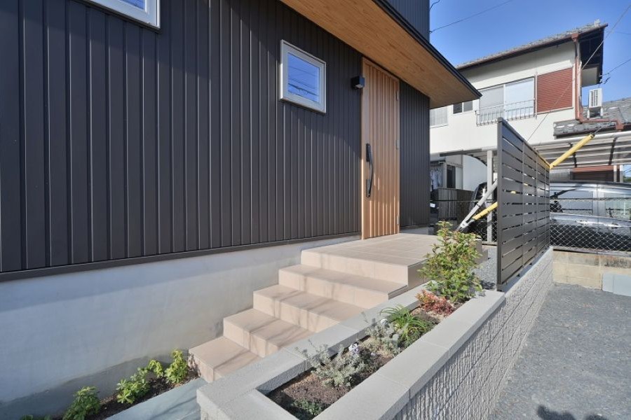 グレーの外壁の住宅と玄関につながる階段