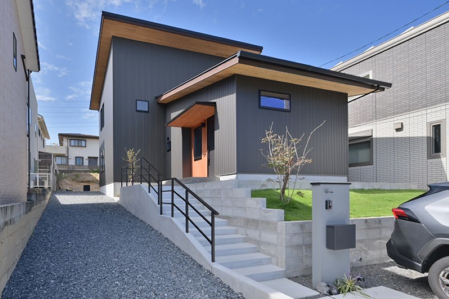石が敷かれた外構のあるグレーの外壁の住宅