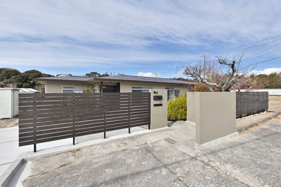 木製フェンスのある家の前の様子